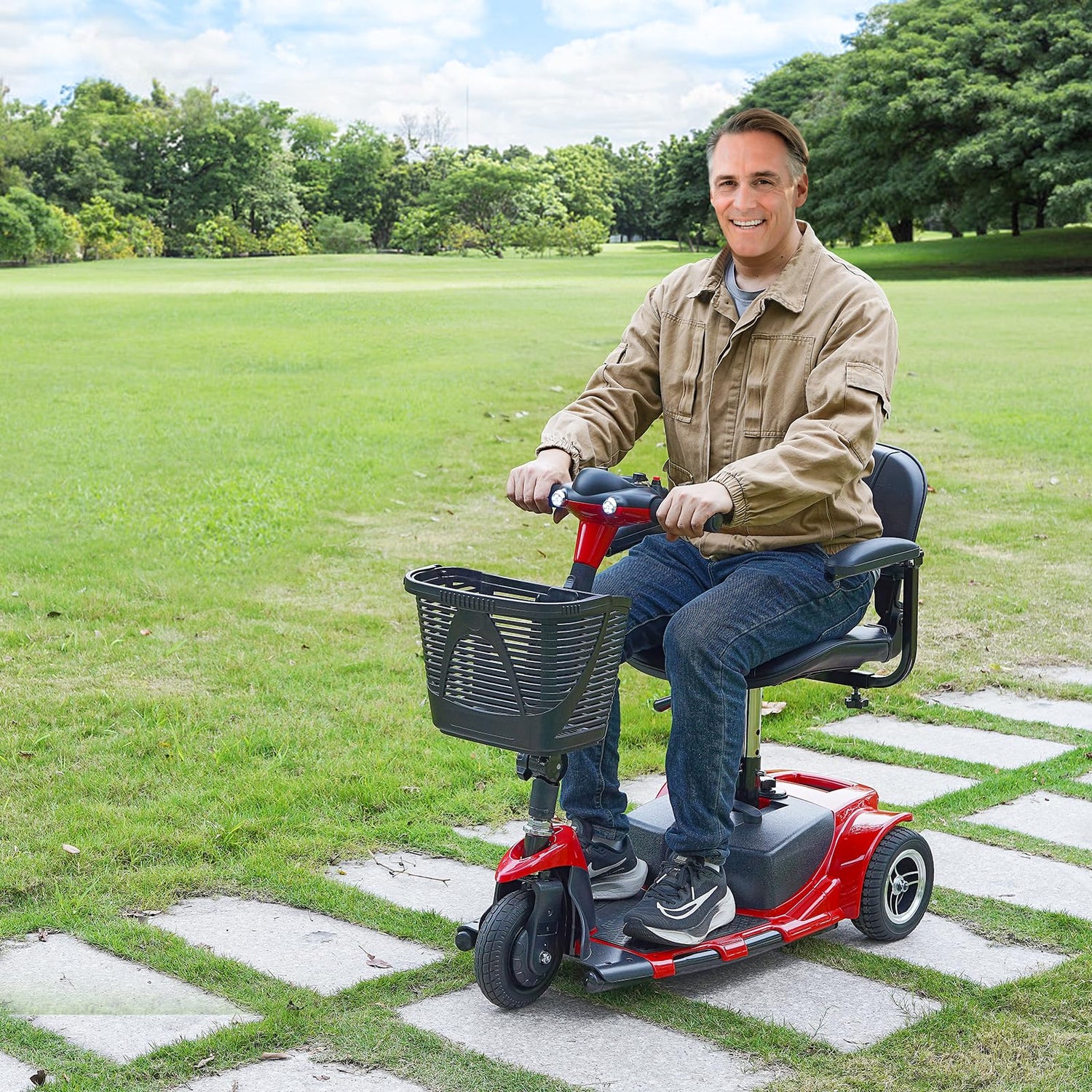 Man riding a mobility scooter in a park with green grass and trees.